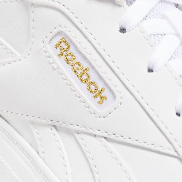 Womens Reebok Classics Court Advance Clip Trainers in white - gold.All the Reebok court design you love. These shoes mash up the icons Club C 85 and Club C Revenge to make the new Court Advance. The tennis-inspired low-top silhouette features a sleek panelled upper with a contrast heel clip and classic windowbox. Foam cushioning and DMX bubbles at the sole provide all-day comfort.- Synthetic upper.- Lace-up front fastening.- Padded ankle collar and tongue.- Perforated toe box.- Reinforced toe cap.- Logo at heel and windowbox.- Logo tab at tongue.- EVA foam midsole with debossed stripes.- DMX Microbubbles in midsole.- Rubber outsole.- Ref: 100207971