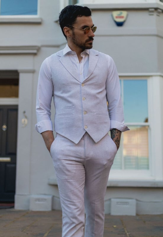 Embrace effortless summer sophistication with this grey 2-piece linen suit, designed with comfort and style in mind. Featuring a coordinating waistcoat and trousers, this ensemble is ideal for warm-weather occasions. The lightweight and breathable linen blend keeps you cool and comfortable, even on the hottest days. With its relaxed yet refined appearance, this suit strikes the perfect balance between smart and casual—ideal for garden parties, destination weddings, or daytime events. Whether dressed up with a crisp shirt or styled casually with loafers, this suit adapts easily to your look and lifestyle.\n2-piece set includes waistcoat and trousers in a light grey tone\nLightweight and breathable fabric perfect for summer events\nRelaxed yet stylish look, ideal for casual weddings or garden parties\nVersatile styling—elevate with formalwear or dress down for smart-casual looks\nMaterial: 80% Cotton, 20% Acrylic