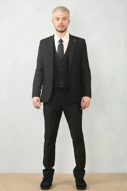 Step into timeless elegance with this tailored black 3-piece suit, designed to deliver both sophistication and comfort for any formal occasion. The classic plain black design ensures versatility across events—from weddings and proms to business meetings and evening functions. Expert tailoring offers a flattering, structured fit, while subtle stitch lapel detailing adds a refined touch. Complete with a blazer, waistcoat, and trousers, this suit is your go-to choice for a polished and confident look.\nTailored Fit: Structured for a modern silhouette that blends style and comfort.\nClassic Plain Black Design: Sleek and versatile, perfect for formal and professional events.\nComplete 3-Piece Set: Includes blazer, waistcoat, and trousers for a coordinated look.\nStitch Lapel Detailing: Adds subtle refinement and character to the overall design.\nMaterial Composition: 65% Polyester, 32% Viscose, 3% Lycra.