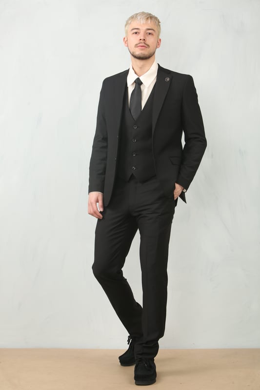 Step into timeless elegance with this tailored black 3-piece suit, designed to deliver both sophistication and comfort for any formal occasion. The classic plain black design ensures versatility across events—from weddings and proms to business meetings and evening functions. Expert tailoring offers a flattering, structured fit, while subtle stitch lapel detailing adds a refined touch. Complete with a blazer, waistcoat, and trousers, this suit is your go-to choice for a polished and confident look.\nTailored Fit: Structured for a modern silhouette that blends style and comfort.\nClassic Plain Black Design: Sleek and versatile, perfect for formal and professional events.\nComplete 3-Piece Set: Includes blazer, waistcoat, and trousers for a coordinated look.\nStitch Lapel Detailing: Adds subtle refinement and character to the overall design.\nMaterial Composition: 65% Polyester, 32% Viscose, 3% Lycra.
