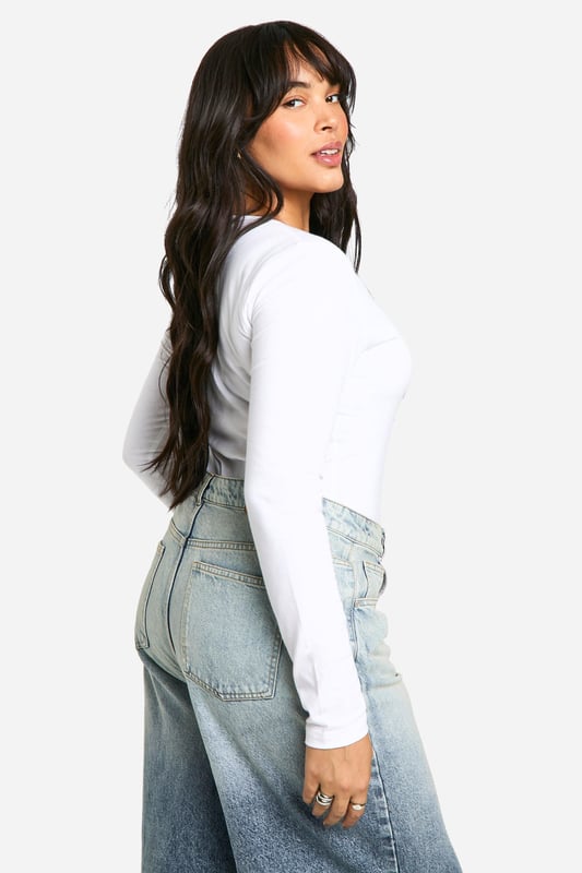 Plunge neckline for a daring look
        Long sleeves for versatile styling
        Figure-hugging bodysuit design
        Soft cotton blend fabric for comfort
        Plus size fit for inclusive fashion
    
    This long-sleeved bodysuit is a wardrobe essential that combines style and comfort effortlessly. The plunging neckline adds a touch of allure, making it perfect for both day and night looks. Pair it with high-waisted wide-leg jeans and trainers for a casual daytime ensemble, or dress it up with a sleek midi skirt and heels for evening drinks. The cotton blend fabric ensures breathability and ease of movement, ideal for long days out or cosy nights in. Its versatility shines through as it can be layered under a blazer for a smart-casual office look or worn solo for a night out dancing. This bodysuit is a true fashion chameleon, adapting to your style needs for any casual occasion, from family gatherings to impromptu coffee dates with friends.