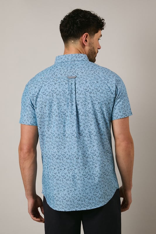 Button-down collar for a classic, structured look
        Delicate ditsy floral print creates a subtle pattern throughout
        Short sleeves with neat hems for warm-weather comfort
        Box pleat at the back for enhanced movement and fit
        Regular fit with curved hem suitable for both tucked and untucked styling
    
    This Maine short sleeve shirt brings a refreshing touch to your casual wardrobe with its charming ditsy floral print. The woven fabric offers a comfortable feel whilst maintaining a smart appearance, perfect for those relaxed yet put-together moments. Style with dark chino shorts and white trainers as shown for effortless summer outings, or pair with slim-fit denim and canvas shoes for weekend brunches. The versatile design works brilliantly for family gatherings, garden parties, or casual Friday office settings. For cooler evenings, layer under a lightweight bomber jacket or cardigan without compromising on style. The button-down collar adds structure to this otherwise laid-back piece, making it an essential addition to your warm-weather collection that transitions seamlessly from daytime casual to evening socialising.