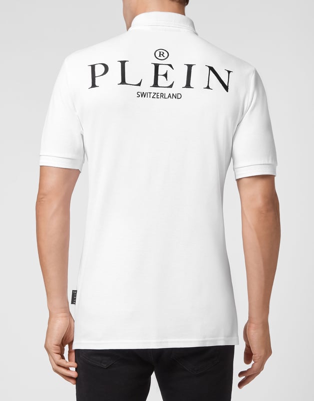 Poloshirt aus Baumwollpikee. Der Skull&Bones ist links auf der Brust gestickt und der Schriftzug im Gothic-Stil ist unter dem Kragen jacquardgewebt. Auf der Passe ist ein Patch aus Saffianleder mit dem PP Hexagon aufgenäht. Knopfverschluss am Kragen. Kragen und Bündchen aus Rippstrick. Asymmetrischer unterer Saum mit zwei Seitenschlitzen und zwei Nadelnähten.