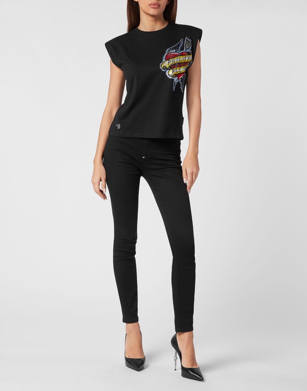 Esta camiseta de tirantes con hombreras combina el arte de los tatuajes vintage con una estructura atrevida, perfecta para combinar con vaqueros de cintura alta o con cuero para lucir un estilo seguro y a la última.   Los hombros acolchados esculpen una silueta poderosa y moderna.   El gráfico inspirado en los tatuajes aporta un encanto rebelde con detalles vibrantes   El tejido de algodón puro ofrece suavidad y comodidad transpirable   Los adornos de fibra de vidrio añaden un brillo sutil y un acabado de lujo   Una pieza destacada para looks de día a noche con actitud