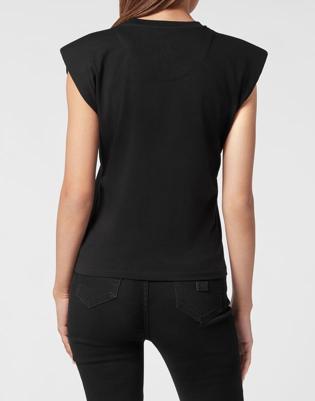 Esta camiseta de tirantes con hombreras combina el arte de los tatuajes vintage con una estructura atrevida, perfecta para combinar con vaqueros de cintura alta o con cuero para lucir un estilo seguro y a la última.   Los hombros acolchados esculpen una silueta poderosa y moderna.   El gráfico inspirado en los tatuajes aporta un encanto rebelde con detalles vibrantes   El tejido de algodón puro ofrece suavidad y comodidad transpirable   Los adornos de fibra de vidrio añaden un brillo sutil y un acabado de lujo   Una pieza destacada para looks de día a noche con actitud