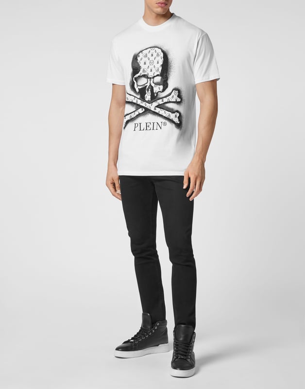 Camiseta de punto de algodón presenta el estampado en los cristales de strass de la calavera icónica. Tira para colgar metálica  con logotipo está cosido en el canesú. Pespunte doble.