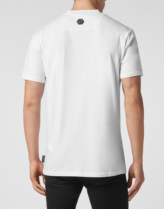 Camiseta de punto de algodón presenta el estampado en los cristales de strass de la calavera icónica. Tira para colgar metálica  con logotipo está cosido en el canesú. Pespunte doble.
