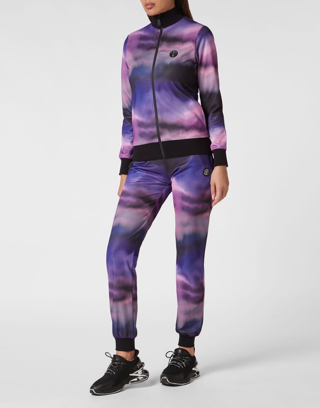 Jogginganzug Entdecke den neuen Trainingsanzug, mit dem du beim Sport und in der Freizeit eine gute Figur machen. Optischer Druck mit Farbverläufen, Baumwollmischung, Triacetat Die Marke ist auf der Rückseite des Oberteils abgebildet Gummierter Aufnäher mit dem Brand-Emblem auf der Jacke und der Hose Wasserdichter Reißverschluss an der Jacke Schlitztaschen Rippstrickbündchen