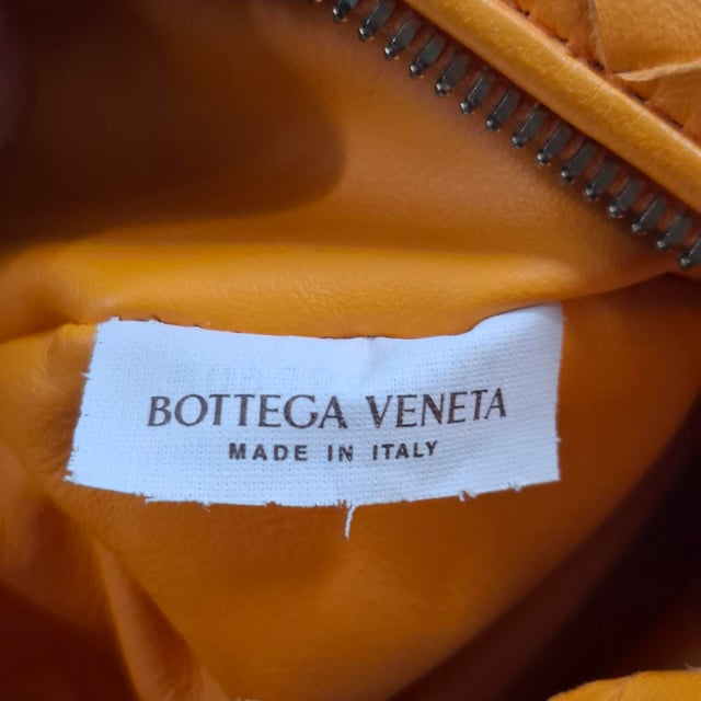 VINTAGE, RRP AS NEW
The Bottega Veneta Mini Jodie in vibrant orange intrecciato leather is the ultimate expression of compact luxury. Its sculptural silhouette and signature woven design make it instantly recognizable, while gold-tone hardware and calfskin lining add refined detail. This top-handle bag is made for effortless impact, from brunch dates to evenings out.

with dust bag

Bottega Veneta Mini Jodie in Orange Leather
Condition: Very good
Signs of wear: No retail tag, Minor sign of wear or markings., Lightly used but very well maintained. Minor creasing, light worn corners, light scratches.
Packaging: Dust bag
Color: Orange
Material: Leather | leather
Size: One Size | One Size
Measurements: Width: 260; Height: 200; Length: 250; Handle drop: 240; Strap length: 0
SKU: NAPPUGBBA475928W