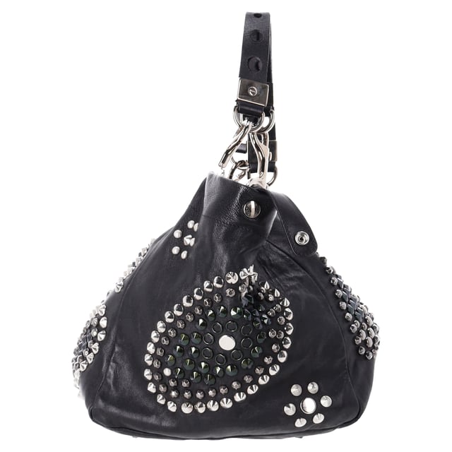 VINTAGE, RRP AS NEW
The Jimmy Choo Lola Hobo Bag is where luxury meets edge. Crafted from ultra-soft lambskin leather, this slouchy bag is adorned with bold studs and intricate mosaic pattern cutouts, adding a glamorous twist to an iconic shape. With its relaxed silhouette and attention-grabbing details, it’s a perfect companion for the fashion-forward woman who wants to turn heads wherever she goes.



Jimmy Choo Studded Lola Hobo Bag in Black Lambskin Leather 
Condition: Very good
Signs of wear: No retail tag, Minor sign of wear or markings., 
Packaging: None
Color: black
Material: Leather | leather
Size: One Size | One Size
Measurements: Width: 280; Height: 470; Length: 300; Handle drop: 0; Strap length: 560
SKU: NAPPUDEBA471166W