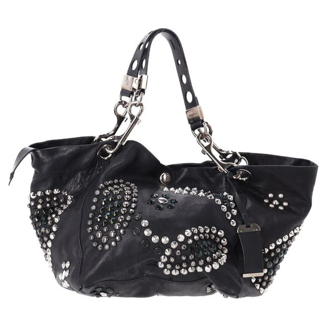 VINTAGE, RRP AS NEW
The Jimmy Choo Lola Hobo Bag is where luxury meets edge. Crafted from ultra-soft lambskin leather, this slouchy bag is adorned with bold studs and intricate mosaic pattern cutouts, adding a glamorous twist to an iconic shape. With its relaxed silhouette and attention-grabbing details, it’s a perfect companion for the fashion-forward woman who wants to turn heads wherever she goes.



Jimmy Choo Studded Lola Hobo Bag in Black Lambskin Leather 
Condition: Very good
Signs of wear: No retail tag, Minor sign of wear or markings., 
Packaging: None
Color: black
Material: Leather | leather
Size: One Size | One Size
Measurements: Width: 280; Height: 470; Length: 300; Handle drop: 0; Strap length: 560
SKU: NAPPUDEBA471166W