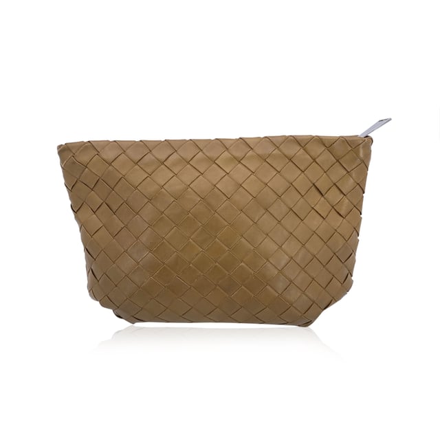 VINTAGE, RRP AS NEW
Bottega Veneta Intrecciato Zip Pouch - A Touch of Woven Gold  There's something unmistakably timeless about Bottega Veneta's craftsmanship-and this Intrecciato Zip Pouch Wristlet is no exception. Woven from buttery-soft lambskin leather in a luminous gold tan, it captures the quiet luxury the house is celebrated for. Compact yet refined, it's the kind of piece that slips effortlessly from day to night, always adding a touch of artisanal elegance.  Secured with a zip closure and adorned with silver-tone hardware, the exterior is a work of woven art, while the matching lambskin-lined interior offers a simple open compartment and a single patch pocket for essentials. Discreetly stamped with 'Bottega Veneta - Made in Italy' and its original ity label, this clutch is more than a bag-it's a moment of Italian design history you can hold in your hand.  Perfect for collectors, minimalists, and lovers of enduring beauty in small forms. Condition Rating: B - VERY GOOD CONDITIONCondition Details: Some darkness on leather along the opening, on a side. A couple of pen marks internally. Please check the photos carefully and ask if you need to know more details or if you have any doubts.Measurements (cm):Depth: 5.1Height: 17.8Length: 27.9Other Details: Dustbag? NoKeys? NoBox? No Measurments:  width: 51 mm length: 279 mm height: 178 mm