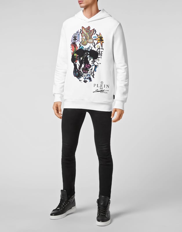 Verfraaid  Katoenen fleece unisex jogging hoodie. De iconische doodskop met strasopdruk siert het kledingstuk. Twee steekzakken. Ribgebreide zomen.