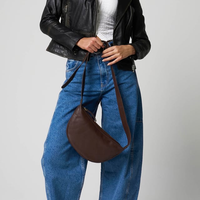 Everyday style with this beautifully crafted cross body bag in rich ruby chocolate brown. Made from supple real goat leather, this bag features a secure zip closure and an adjustable strap for a comfortable, custom fit. Compact and stylish, it’s perfect for carrying your daily essentials with ease and sophistication.