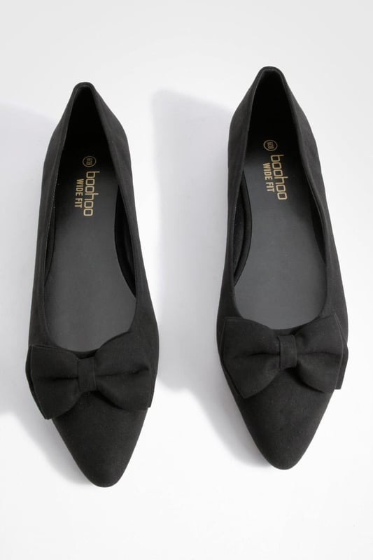 Charming bow detail adorns the toe
        Wide fit design for enhanced comfort
        Versatile round toe silhouette
        Flat sole for all-day wearability
        Soft synthetic suede upper for a luxe look
    
    Step out in style and comfort with these delightful wide fit ballerina flats. The eye-catching bow detail adds a touch of femininity to the classic round toe design, making these shoes a perfect blend of elegance and practicality. Ideal for the fashion-forward woman who values both style and comfort, these flats can effortlessly transition from day to night. Pair them with cropped trousers and a crisp white shirt for a polished office look, or team them with a flowy summer dress for a casual day out with friends. The versatile nature of these ballerinas makes them a wardrobe essential for various occasions, from family gatherings to impromptu coffee dates. With their wide fit and soft synthetic suede upper, these shoes promise to keep your feet feeling fabulous all day long, no matter where your adventures take you.