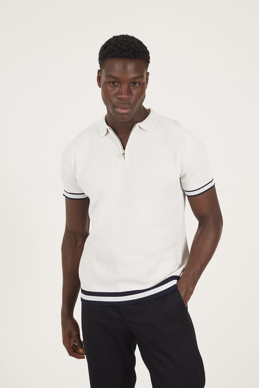 Elevate your smart-casual style with this polo from Brave Soul, designed with a sleek concealed 1/4 zip neck fastening for a clean, contemporary finish. Made from an all-over rib knit fabric, this polo offers a comfortable stretch fit with refined texture. Contrast stripe trims at the collar and cuffs add a pop of detail, to this elevated everyday essential. Model wears UK size M.