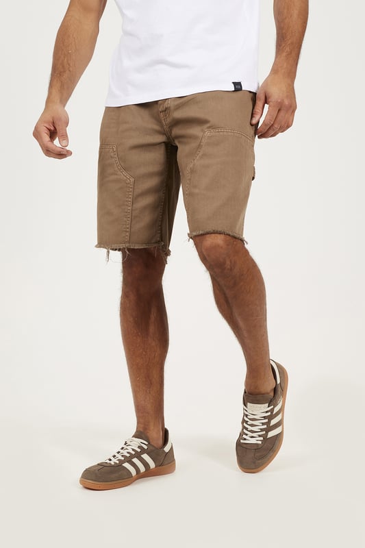 Bring a rugged twist to your summer wardrobe with these carpenter-style denim shorts from Brave Soul. Designed in a loose fit with a classic button waist, these shorts deliver easy comfort and authentic utility style. Crafted from sturdy denim, they feature carpenter-style thigh pockets and a raw hem for an effortlessly worn-in edge. Model wears UK size M.