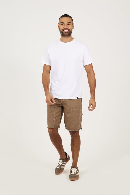 Bring a rugged twist to your summer wardrobe with these carpenter-style denim shorts from Brave Soul. Designed in a loose fit with a classic button waist, these shorts deliver easy comfort and authentic utility style. Crafted from sturdy denim, they feature carpenter-style thigh pockets and a raw hem for an effortlessly worn-in edge. Model wears UK size M.