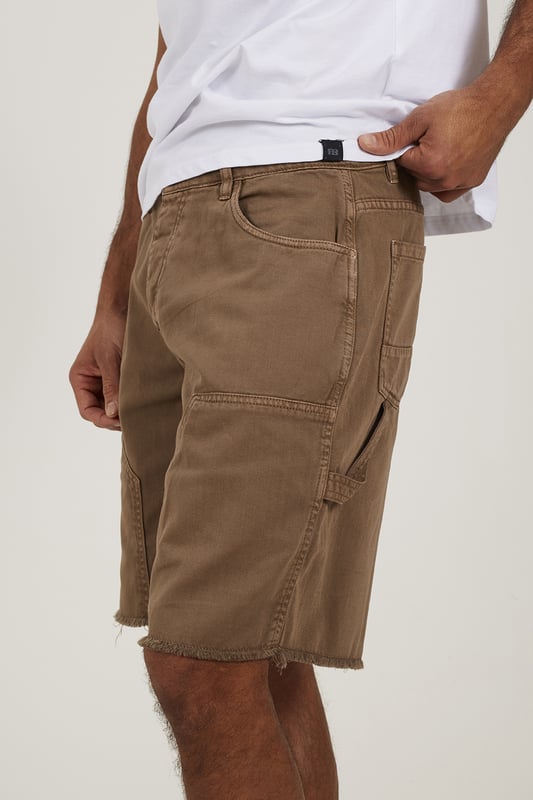 Bring a rugged twist to your summer wardrobe with these carpenter-style denim shorts from Brave Soul. Designed in a loose fit with a classic button waist, these shorts deliver easy comfort and authentic utility style. Crafted from sturdy denim, they feature carpenter-style thigh pockets and a raw hem for an effortlessly worn-in edge. Model wears UK size M.