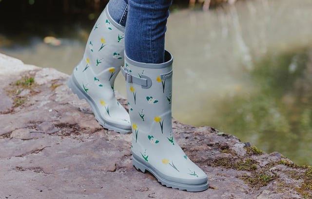 Ontworpen met inspiratie afkomstig van de glooiende heuvels en bloeiende weilanden van de Cotswolds, zijn deze hoge Wellington laarzen een ode aan de natuur en comfort. De duurzame rubberen bovenkant is versierd met fijne, handgetekende illustraties van wilde bloemen, elk exclusief voor Cotswold Shoes en gemaakt om de levendige flora in onze lokale landschappen te weerspiegelen. Deze laarzen zijn niet alleen mooi om naar te kijken, maar zijn ook praktisch ingericht. De waterdichte constructie zorgt ervoor dat je voeten droog blijven in nat weer. Binnenin bieden de zachte memory foam voetbedden extra steun, waardoor deze laarzen perfect zijn voor lange wandelingen op het platteland, tuinieren of klusjes op regenachtige dagen. Of je nu modderige paden verkent of gewoon een bloemige toets aan je dagelijkse outfit wilt toevoegen, de Wildflower Tall Wellingtons bieden de perfecte combinatie van stijl, comfort en functionaliteit. 
 - Duurzame rubberen bovenkant
 - Waterdichte constructie
 - Handgetekende illustraties
 - Zacht memory foam voetbed
 - Cotswold branding