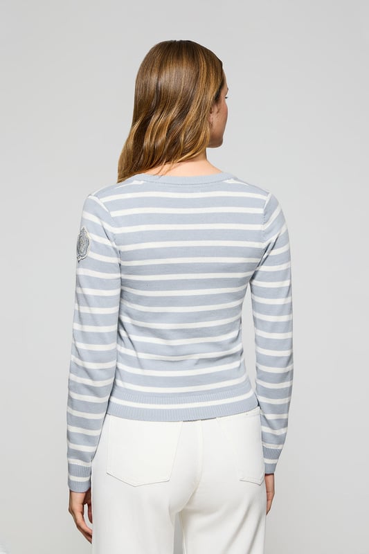 Die Damenstrickjacke Cordelia ist ein maritim inspiriertes Stück, das Eleganz und Funktionalität vereint. Sie ist aus Baumwolle und Polyamid gefertigt und hat eine schmale Passform mit V-Ausschnitt, die eine schlanke Silhouette schafft. Der Knopfverschluss mit farblich abgestimmten Logoknöpfen sorgt für ein raffiniertes Finish, während die Rippbündchen an den Ärmeln und am Bund für einen bequemen Sitz sorgen. Das farblich abgestimmte Nahtband am Kragen mit Polo Club Logo unterstreicht die Eleganz dieses Modells. Das kontrastierende Streifendesign und das einfarbige gestickte Wappen auf dem Ärmel sind ikonische Details unserer maritimen Kollektion.