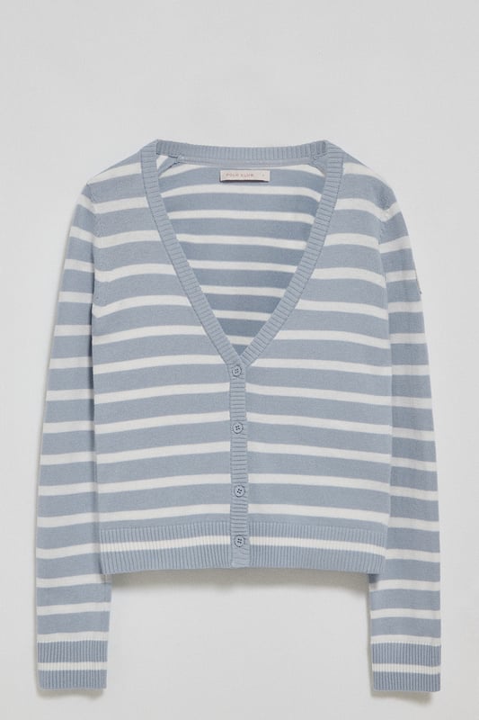 Die Damenstrickjacke Cordelia ist ein maritim inspiriertes Stück, das Eleganz und Funktionalität vereint. Sie ist aus Baumwolle und Polyamid gefertigt und hat eine schmale Passform mit V-Ausschnitt, die eine schlanke Silhouette schafft. Der Knopfverschluss mit farblich abgestimmten Logoknöpfen sorgt für ein raffiniertes Finish, während die Rippbündchen an den Ärmeln und am Bund für einen bequemen Sitz sorgen. Das farblich abgestimmte Nahtband am Kragen mit Polo Club Logo unterstreicht die Eleganz dieses Modells. Das kontrastierende Streifendesign und das einfarbige gestickte Wappen auf dem Ärmel sind ikonische Details unserer maritimen Kollektion.