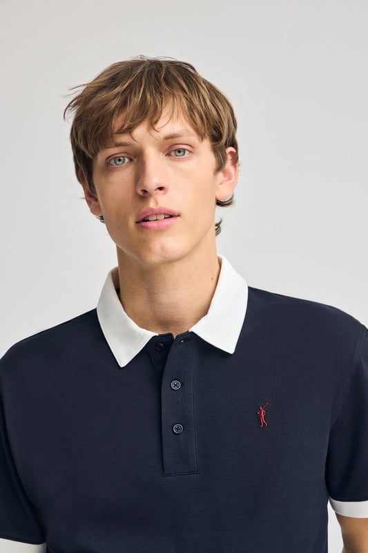 Das Poloshirt Dareh ist die perfekte Kombination aus Komfort und Eleganz. Sein Baumwollpiqué-Gewebe ist angenehm atmungsaktiv und geschmeidig, während kontrastierende Details an Kragen und Ärmeln das Design aufpeppen. Die ikonische Rigby Go Stickerei auf der Brust, die Seitenschlitze und das personalisierte Nahtband machen dieses Poloshirt zu einem einzigartigen und eleganten Kleidungsstück.