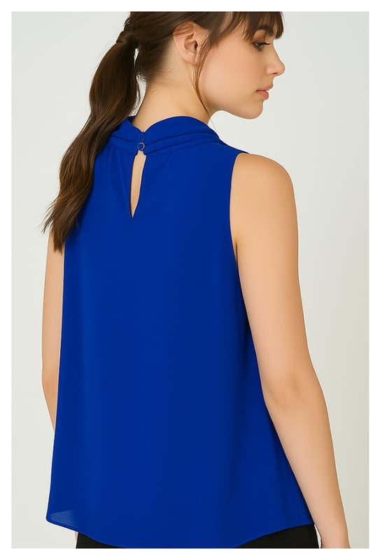 Voeg een vleugje elegantie toe aan je garderobe met deze mouwloze blouse in levendig kobaltblauw. Het is gemaakt van 100% lichtgewicht polyestervoile en valt zacht en luchtig, waardoor het de hele dag comfortabel aanvoelt. Het opvallende detail is de sierlijke halslijn met strikje, die vrouwelijke charme en veelzijdigheid aan je look toevoegt. Draag hem met een pantalon of een rok voor een verzorgde kantooroutfit, of combineer hem met een jeans voor een chique weekendsfeer.