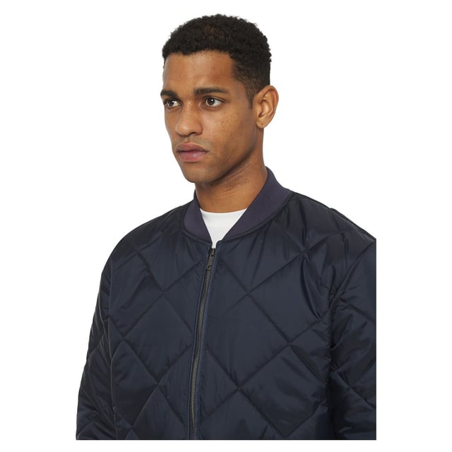 Die diamantartige Steppung verbindet das 100% Nylon-Taffeta-Obermaterial mit dem grauen Jersey-Strickfutter und einer Füllung aus 5 oz Polyester. Ribstrickkragen, -bündchen und Rückenbund. Vorderseite mit Handwärmertaschen.