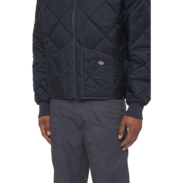 Die diamantartige Steppung verbindet das 100% Nylon-Taffeta-Obermaterial mit dem grauen Jersey-Strickfutter und einer Füllung aus 5 oz Polyester. Ribstrickkragen, -bündchen und Rückenbund. Vorderseite mit Handwärmertaschen.