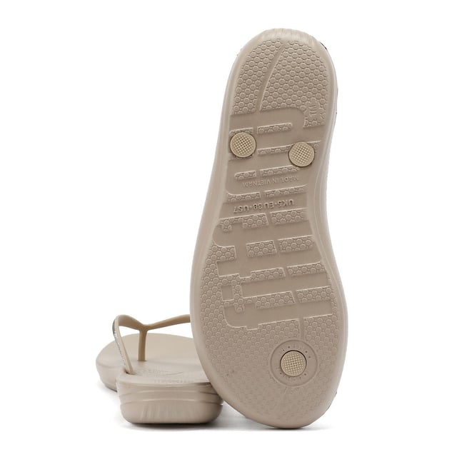 FitFlop Iqushion Ombre Sparkle Women's Taupe/Pewter Flip Flops Waterproof ergonomic flip-flops with a durable rubber upper and anatomically shaped straps for a secure fit adorn with micro-crystals . Designed with a contoured footbed to support natural alignment and reduce toe gripping. Lightweight, flexible, and perfect for beach days, poolside lounging, or everyday summer wear.