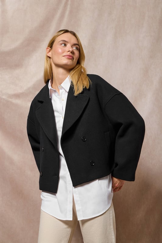 Der Damen-Kurzmantel Lona ist ideal, um jeden Look zu vervollständigen. Er verbindet Stil und Komfort auf perfekte Weise. Er ist aus einem Woll- und Polyestermischgewebe gefertigt. Das größere Revers mit Einschnitt und der Vierknopfverschluss mit Logoprägung verleihen ihm eine klassische, elegante Note. Mit zwei Vordertaschen und einer dezenten Innentasche ist er praktisch und funktionell. Das Polo Club Logo auf der Passe verleiht ihm einen exklusiven Touch. Ein ideales Kleidungsstück für die Übergangszeit oder für kühlere Tage.