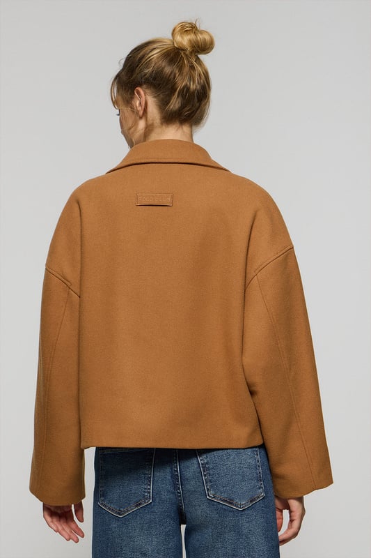 Der Damen-Kurzmantel Lona ist ideal, um jeden Look zu vervollständigen. Er verbindet Stil und Komfort auf perfekte Weise. Er ist aus einem Woll- und Polyestermischgewebe gefertigt. Das größere Revers mit Einschnitt und der Vierknopfverschluss mit Logoprägung verleihen ihm eine klassische, elegante Note. Mit zwei Vordertaschen und einer dezenten Innentasche ist er praktisch und funktionell. Das Polo Club Logo auf der Passe verleiht ihm einen exklusiven Touch. Ein ideales Kleidungsstück für die Übergangszeit oder für kühlere Tage.