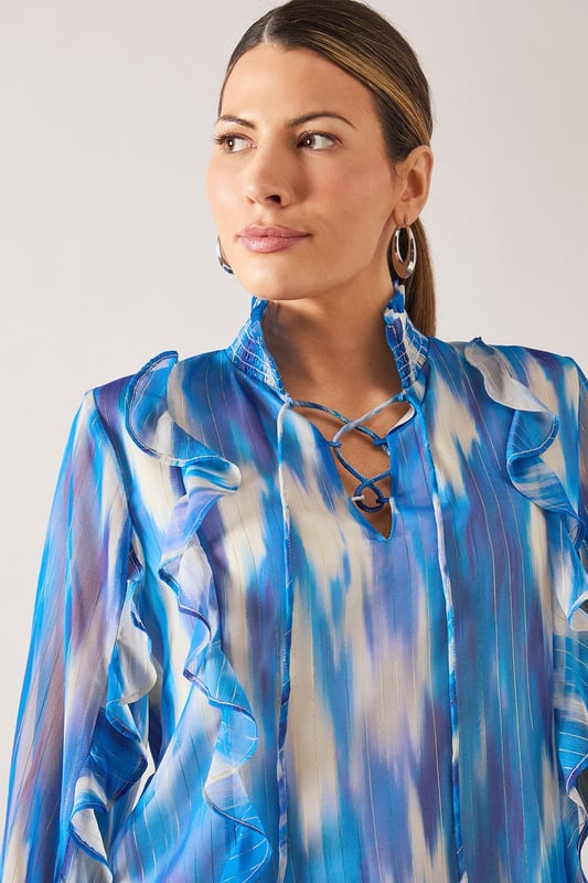 Elegant V-neckline with delicate ruffle detailing along the front
        Flowing long sleeves with gathered cuffs for a feminine silhouette
        Practical chest pockets add functionality to this sophisticated design
        Lightweight spun viscose fabric offers comfort and graceful drape
        Striking watercolour-inspired pattern creates visual interest and versatility
    
    This Wallis shirt combines sophistication with everyday wearability. The fluid silhouette and artistic print make it perfect for elevating your daytime wardrobe. Style with wide-leg trousers as shown for a polished look that works beautifully for lunch dates or family gatherings. For casual outings, pair with your favourite denim and flat sandals. The versatile design transitions effortlessly from office to weekend, simply by changing your accessories. Add statement earrings and a delicate necklace to draw attention to the flattering V-neckline. The ruffle detailing adds a touch of glamour whilst maintaining the shirt's comfortable, relaxed feel - ideal for the woman who appreciates both style and practicality in her wardrobe essentials.
