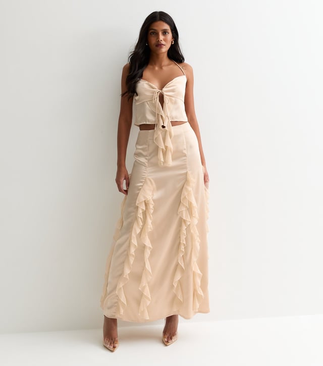 Indulge in luxury with our Champagne Satin Ruffle Tie Front Top. The smooth and lustrous satin fabric drapes elegantly and the ruffle and tie front details add a touch of sophistication. Perfect for any occasion, this top will make you feel glamorous and exclusive.