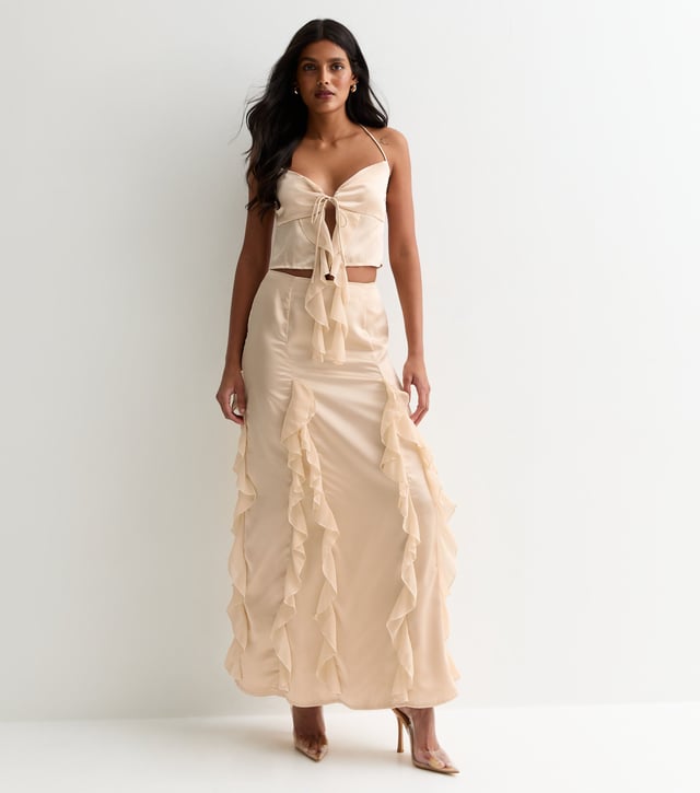 Eleva tu vestuario con nuestra Maxifalda de Satén con Volantes Champán. El lujoso material satinado y los detalles de volantes añaden un toque de sofisticación a cualquier conjunto. Mantente elegante y cómoda con esta prenda atrevida y versátil.