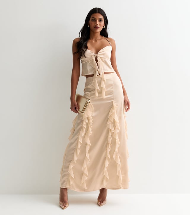 Eleva tu vestuario con nuestra Maxifalda de Satén con Volantes Champán. El lujoso material satinado y los detalles de volantes añaden un toque de sofisticación a cualquier conjunto. Mantente elegante y cómoda con esta prenda atrevida y versátil.
