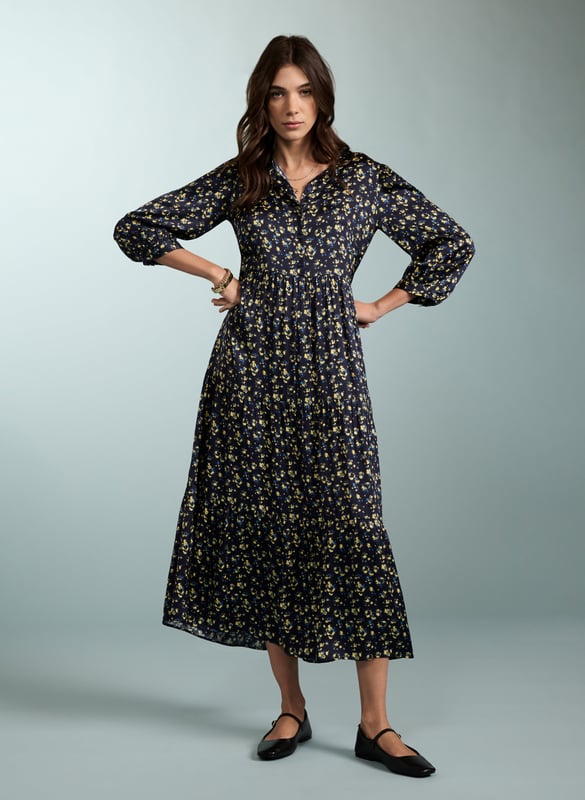 Description\nPurnita brings together details from our most popular dresses, such as a simple, throw-on shape with a tiered skirt, a button-down front, and of course - pockets! Its blurred ditsy print is so easy to style - see for yourself with leather biker or denim jackets, and any kind of footwear.  \n\nMade in Europe\nCrafted in a recycled satin blend \nElbow length sleeves with button fastening \nButtons to the waist seam \nMidi length \n\n\nSustainable Attributes:\n  Low impact \n   Low Water Use\n    Recycled Fibres \n   Ethically made\n   Vegan \n   \n\nDetails\nModel is 5'10 (177cm) and is wearing a UK 1049% LENZING™ ECOVERO™ Viscose, 51% Recycled ViscoseDelicate Machine Wash 30˚Product code: DR40568-BUDBack shoulder at neck to hem - 125cm (49 3/8)Sleeve length - 55cm (21 5/8)