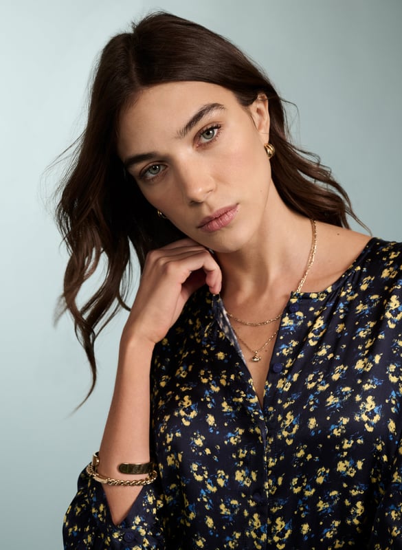Description\nPurnita brings together details from our most popular dresses, such as a simple, throw-on shape with a tiered skirt, a button-down front, and of course - pockets! Its blurred ditsy print is so easy to style - see for yourself with leather biker or denim jackets, and any kind of footwear.  \n\nMade in Europe\nCrafted in a recycled satin blend \nElbow length sleeves with button fastening \nButtons to the waist seam \nMidi length \n\n\nSustainable Attributes:\n  Low impact \n   Low Water Use\n    Recycled Fibres \n   Ethically made\n   Vegan \n   \n\nDetails\nModel is 5'10 (177cm) and is wearing a UK 1049% LENZING™ ECOVERO™ Viscose, 51% Recycled ViscoseDelicate Machine Wash 30˚Product code: DR40568-BUDBack shoulder at neck to hem - 125cm (49 3/8)Sleeve length - 55cm (21 5/8)