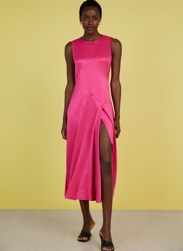 Description\nFits smaller to size, we suggest sizing up from your usual size\nPrepare to turn heads in Soleil! This feelgood frock comes in the most dazzling shade of pink, and a wonderfully resourceful fabric called Ecojilin, which makes use of recycled fibres. The result is a drapey dress with a luxe, satin finish and a sexy split for good measure. Just add heels and earrings and you’re ready to wow! \n\nCrafted in Ecojilin using recycled cotton fibres \nLong midi length\nDiagonally-cut seams for shaping\nSkims the waist and hips then flares out\nFastens with a button to the rear neck\nSide seam zip\n\n\nSustainable Attributes:\n Made in Europe   Low Impact  Low Water Use  Recycled Fibres  Ethically made   Vegan   Low Carbon  \n\nDetails\n100% Ecojilin ViscoseDry Clean OnlyProduct code: DR40493-HYPBack shoulder at neck to hem - 129cm (50 3/4)