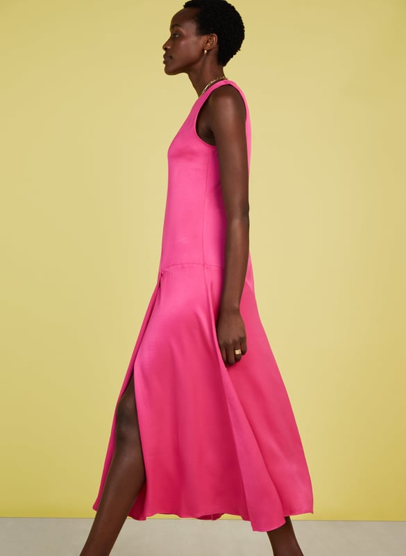 Description\nFits smaller to size, we suggest sizing up from your usual size\nPrepare to turn heads in Soleil! This feelgood frock comes in the most dazzling shade of pink, and a wonderfully resourceful fabric called Ecojilin, which makes use of recycled fibres. The result is a drapey dress with a luxe, satin finish and a sexy split for good measure. Just add heels and earrings and you’re ready to wow! \n\nCrafted in Ecojilin using recycled cotton fibres \nLong midi length\nDiagonally-cut seams for shaping\nSkims the waist and hips then flares out\nFastens with a button to the rear neck\nSide seam zip\n\n\nSustainable Attributes:\n Made in Europe   Low Impact  Low Water Use  Recycled Fibres  Ethically made   Vegan   Low Carbon  \n\nDetails\n100% Ecojilin ViscoseDry Clean OnlyProduct code: DR40493-HYPBack shoulder at neck to hem - 129cm (50 3/4)