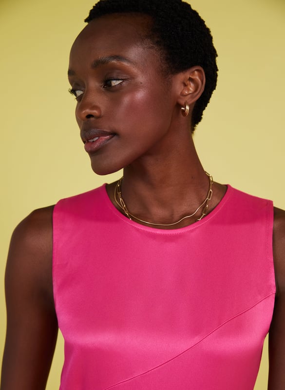 Description\nFits smaller to size, we suggest sizing up from your usual size\nPrepare to turn heads in Soleil! This feelgood frock comes in the most dazzling shade of pink, and a wonderfully resourceful fabric called Ecojilin, which makes use of recycled fibres. The result is a drapey dress with a luxe, satin finish and a sexy split for good measure. Just add heels and earrings and you’re ready to wow! \n\nCrafted in Ecojilin using recycled cotton fibres \nLong midi length\nDiagonally-cut seams for shaping\nSkims the waist and hips then flares out\nFastens with a button to the rear neck\nSide seam zip\n\n\nSustainable Attributes:\n Made in Europe   Low Impact  Low Water Use  Recycled Fibres  Ethically made   Vegan   Low Carbon  \n\nDetails\n100% Ecojilin ViscoseDry Clean OnlyProduct code: DR40493-HYPBack shoulder at neck to hem - 129cm (50 3/4)