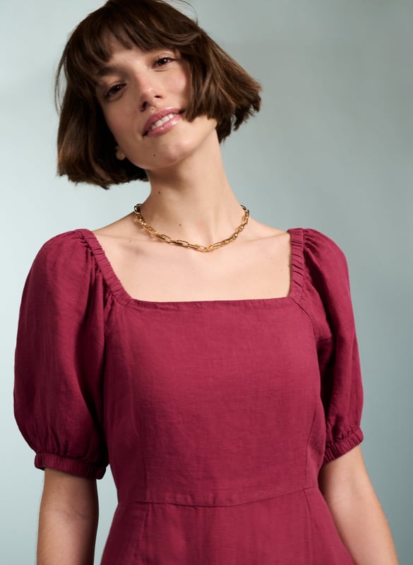 Description\nJuicy like a ripe raspberry and just the right side of crinkly, Nancy is the ultimate summer dress. This style in natural linen comes in a flattering, fit-and-flare silhouette, and a statement square neckline. Its sleeves are pretty and puffy, with elasticated details around the shoulder and cuffs. A style to breeze around in on a hot day, or on holiday, its criss-cross back makes it simply irresistible.\n\nMade in Europe\nCrafted in pure flax linen\nFastens with a concealed center back zip\nCan be worn with a strapless bra\nLong midi length\n\n\nSustainable Attributes:\n  Low Water Use   Natural fibres   Ethically made    Vegan \n\nDetails\n100% LinenDelicate Machine Wash - 30°Product code: DR40475-RASBack shoulder at neck to hem - 120cm (47 1/4)Sleeve length - 35cm (13 3/4)