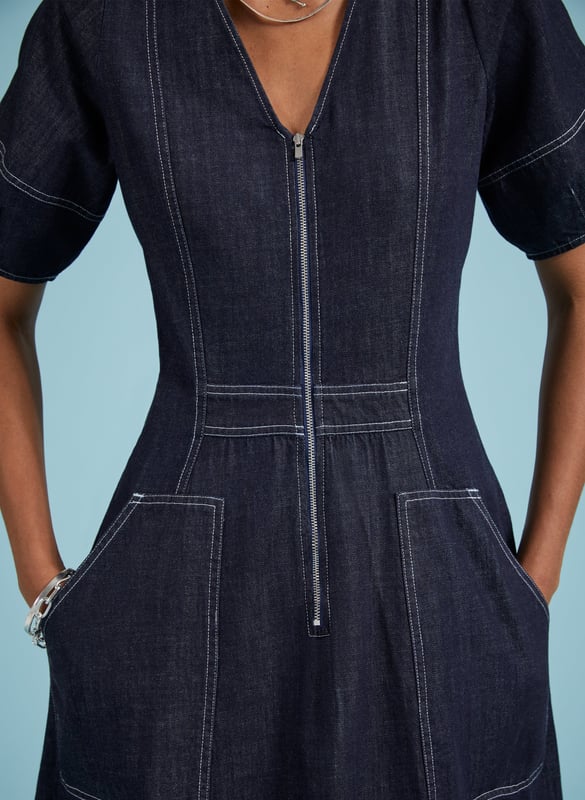 Description\nCoralie is a denim dress you can wear year-round: style it with bare legs and ballet pumps on milder days, then layer it with knee-high boots and a rollneck come winter. Crafted in raw, organic denim and defined by contrast stitching. An elasticated back panel is cut for a waist-accentuating fit and flare shape. Voluminous bell sleeves, and front zip opening top this contemporary design off.\n\nMade in Europe\nCrafted in organic cotton denim\nPockets\nContrast stitching\nBack elastic panel detail for shaping and fit\n\n\nSustainable Attributes:\n  Low Impact   Low Water Use   Natural fibres   Organic   Ethically made   Low Carbon \n\nDetails\nModel is 5'10 (177cm) and is wearing a UK 10100% Organic Cotton Delicate Machine Wash - 30°Product code: DR40576-DARBack shoulder at neck to hem - 123cm (48 3/8)Sleeve length - 31cm (12 1/4)