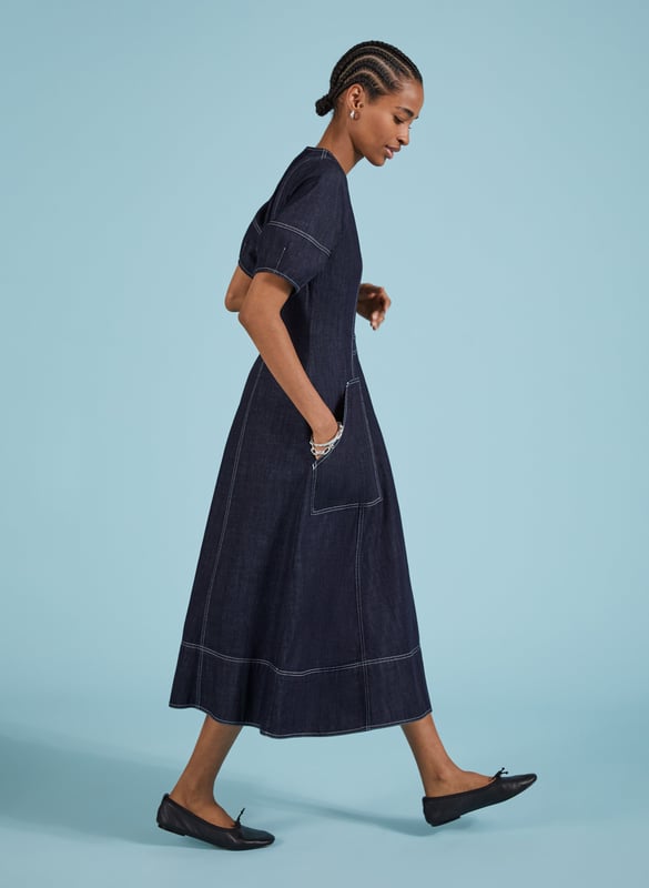 Description\nCoralie is a denim dress you can wear year-round: style it with bare legs and ballet pumps on milder days, then layer it with knee-high boots and a rollneck come winter. Crafted in raw, organic denim and defined by contrast stitching. An elasticated back panel is cut for a waist-accentuating fit and flare shape. Voluminous bell sleeves, and front zip opening top this contemporary design off.\n\nMade in Europe\nCrafted in organic cotton denim\nPockets\nContrast stitching\nBack elastic panel detail for shaping and fit\n\n\nSustainable Attributes:\n  Low Impact   Low Water Use   Natural fibres   Organic   Ethically made   Low Carbon \n\nDetails\nModel is 5'10 (177cm) and is wearing a UK 10100% Organic Cotton Delicate Machine Wash - 30°Product code: DR40576-DARBack shoulder at neck to hem - 123cm (48 3/8)Sleeve length - 31cm (12 1/4)