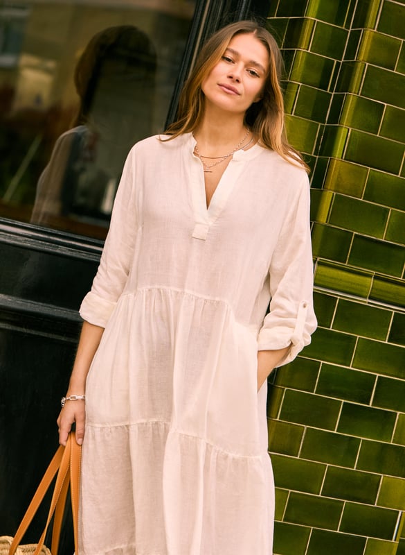 Description\nWe’ve given the classic shirt dress a relaxed, linen makeover for warm weather. Brenda features a notched collar with placket and is softened with a tiered, floaty skirt. On the full-length sleeves we’ve included tabs, so they’re easy to roll up. It’s your must-have for summer in the city - and on holiday. \n”My favourite dress for summer. Cool in white, happy in emerald” - Baukjen\n\nMade in Europe\nCrafted in linen\nPockets in side seams\nSimply pulls on \n\n\nSustainable Attributes:\n\n\n Low Water Use\n\n Natural fibres\n\n Ethically made\n\nDetails\nModel is 5'10 (177cm) and is wearing a UK 10\n100% Linen \nDelicate Machine Wash - 30°\nProduct code: DR40594-SFW \nBack shoulder at neck to hem - 129cm (50 3/4)\nSleeve length - 41cm (16 1/8)