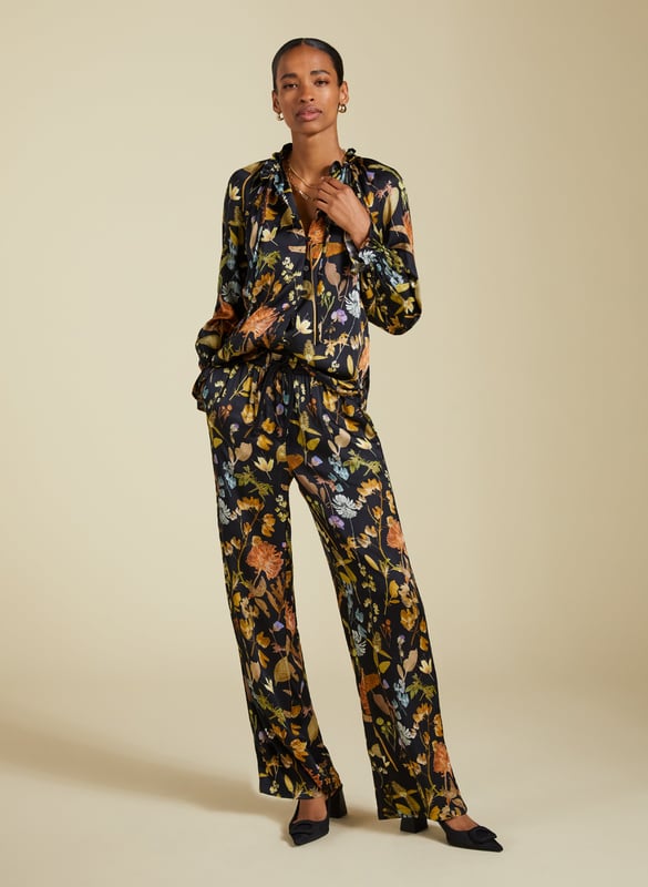 Description\nFits true to size, we suggest ordering your usual size.\nInject a little fun into your trouser collection with the Mandy Satin Trousers. This style boasts a beautiful botanical print on a black base, lending interest to crisp white blouses and oversize tees. But our favourite way to style them is with the matching Jasmine Satin Blouse for a considered co-ord. Cut for a wide-leg, pyjama-style silhouette, they are the ultimate spring-in-your-step piece.\n\nMade in Europe\nCrafted in a recycled satin blend\nElasticated waist with draw-cord\nSide slash pockets and back patch pockets\nWide-leg, relaxed fit\nBlack piping detail down each leg\nMatching shirt available\n\n\nSustainable Attributes:\n  Low Impact   Low Water Use  Ethically made  Low Carbon  \n\nDetails\nModel is 5'10 (177cm) and is wearing a UK 1049% Lenzing™ EcoVero™ Viscose, 51% Recycled ViscoseDelicate Machine Wash - 30°Product code: TR40313-BTOInside leg - 77.5cm (30 1/2)