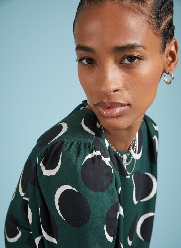 Description\nDottie is a printed blouse that is smart, comfortable and versatile. And will deliver when it comes to dressing for work or dinner. With its shadow spot pattern and beautiful drapey fabric, she won’t let you down. Wear it with tailored trousers for a look that’s as effortless as it is elegant.\n\nMade in Europe\nCrafted in Livaeco viscose\nRouleau loop button back neck fastening\nPleat detailing around shoulders\nRelaxed fit\n\n\nSustainable Attributes:\n  Low impact  Low Water Use   Recycled Fibres   Ethically made  Low Carbon \n\nDetails\nModel is 5'10 (177cm) and is wearing a UK 10100% LivaecoDelicate Machine Wash 30˚Product Code: TP40797-GSSBack shoulder at neck to hem - 62cm (24 2/5)Sleeve length - 62cm (24 3/8)