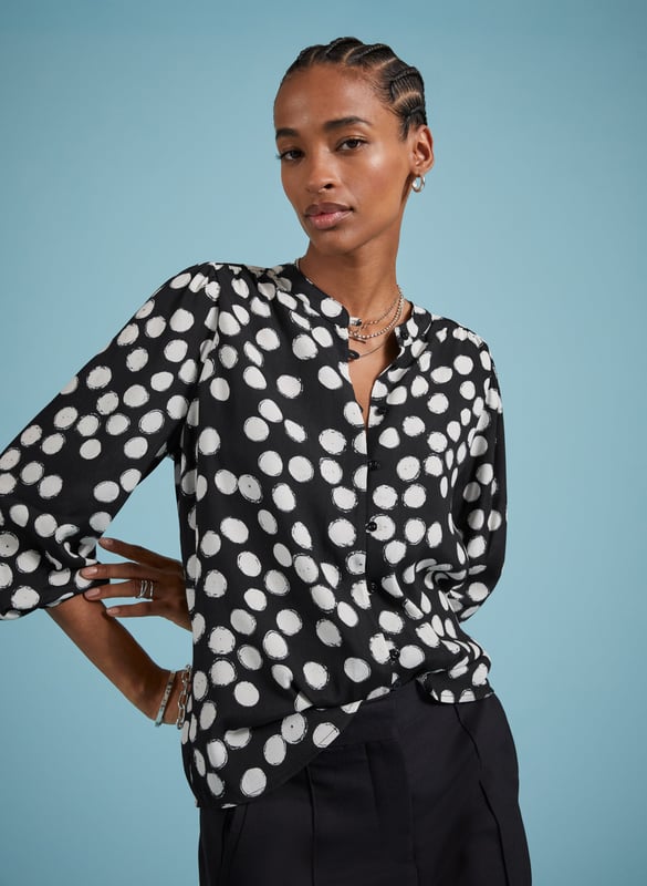 Description\nFits large to size, we suggest sizing down from your usual size.\nOne of our most popular - and elegant - blouse shapes brought to you in a timeless polka print. We love how the Jaqueline instantly elevates the simplest of jeans or trousers in one easy move, thanks to rouleau loop button fastenings, gathered shoulders and deep cuffs. Made from sustainable crepe fabric, it comes in a relaxed fit so it can easily be tucked in.\n\nMade in Europe\nCrafted in viscose crepe with Lenzing™ EcoVero™\nButton-through\nRelaxed fit\n\n\nSustainable Attributes:\n  Low Impact   Low Water Use  Ethically made  Low Carbon \n\nDetails\nModel is 5'10 (177cm) and is wearing a UK 1051% Lenzing™ EcoVero™ Viscose, 49% RCS ViscoseDelicate Machine Wash - 30°Product code: SH40297-BPABack shoulder at neck to hem - 64.cm (25 2/4)Sleeve length - 63.5cm (25)
