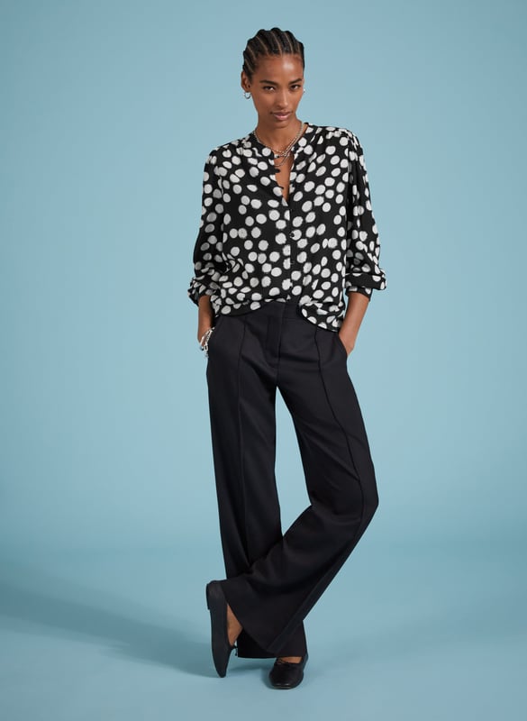 Description\nFits large to size, we suggest sizing down from your usual size.\nOne of our most popular - and elegant - blouse shapes brought to you in a timeless polka print. We love how the Jaqueline instantly elevates the simplest of jeans or trousers in one easy move, thanks to rouleau loop button fastenings, gathered shoulders and deep cuffs. Made from sustainable crepe fabric, it comes in a relaxed fit so it can easily be tucked in.\n\nMade in Europe\nCrafted in viscose crepe with Lenzing™ EcoVero™\nButton-through\nRelaxed fit\n\n\nSustainable Attributes:\n  Low Impact   Low Water Use  Ethically made  Low Carbon \n\nDetails\nModel is 5'10 (177cm) and is wearing a UK 1051% Lenzing™ EcoVero™ Viscose, 49% RCS ViscoseDelicate Machine Wash - 30°Product code: SH40297-BPABack shoulder at neck to hem - 64.cm (25 2/4)Sleeve length - 63.5cm (25)